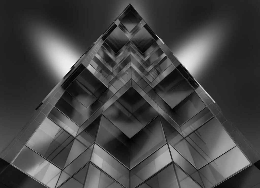 Gray scale low angle shot of a pyramid shaped glass building
